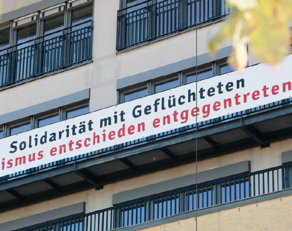 Ein Banner an der Fassade der Hochschule mit der Aufschrift Solidarität mit Geflüchteten