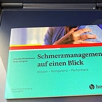Das Buch „Schmerzmanagement auf einen Blick“ an Prof. Winkelmanns Lieblingsleseplatz: Im Zug