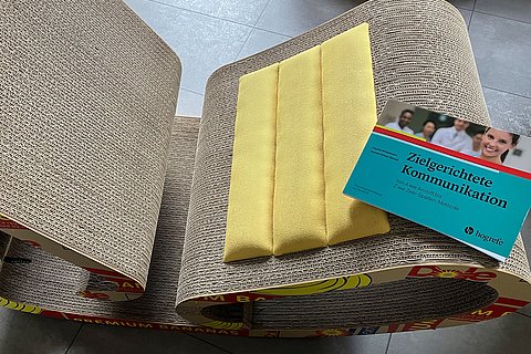 Buch auf einem Schaukelstuhl aus alter Pappe