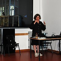 Yevgenia Belorusets steht in einem Seminarraum der ASH Berlin und erläutert den Workshopteilnehmenden den Ablauf des Workshops