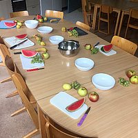 Ein gedeckter Kindertisch mit Melonenscheiben auf den Tellern