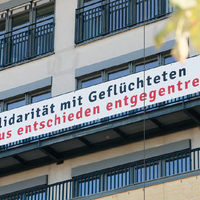 Ein Banner an der Fassade der ASH Berlin mit der Aufschrift: Solidarität mit Geflüchteten Gemeinsam Rassismus entschieden entgegentreten