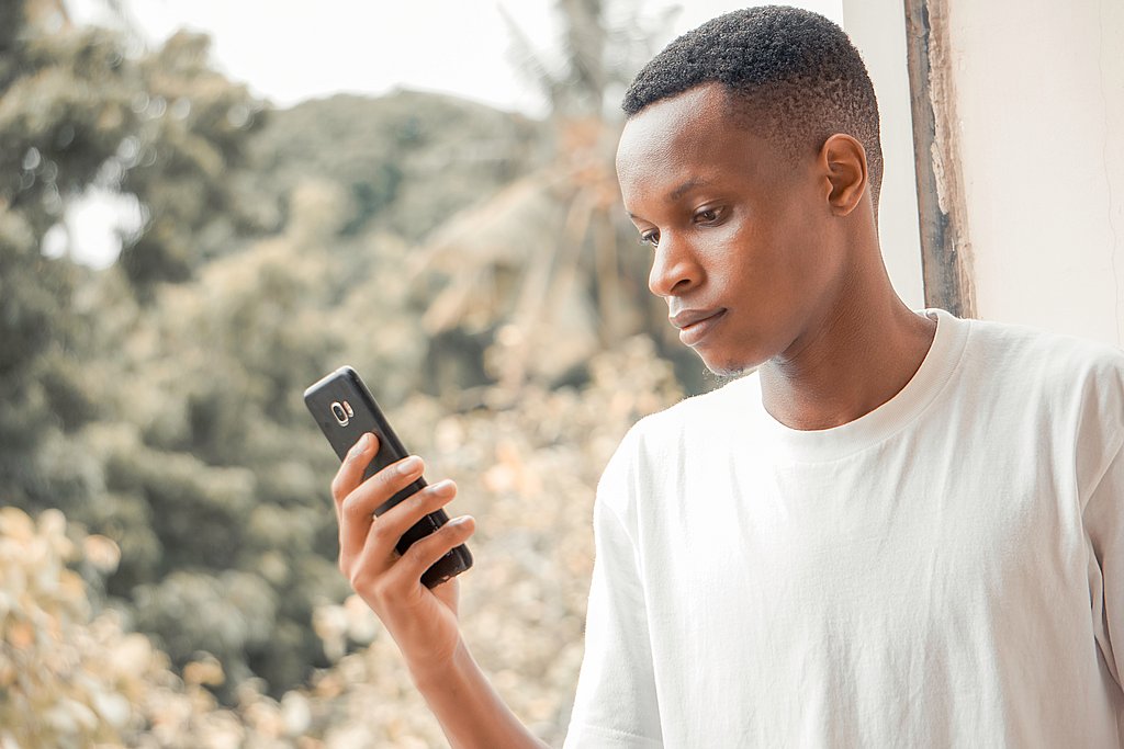 Ein junger Mann schaut in ein Handy