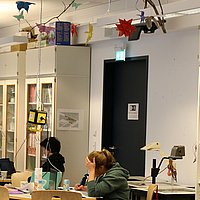 Schreibende Studierende in der Lernwerkstatt, über Labtop gebeugt