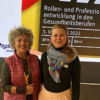 Zwei Frauen vor einem Poster