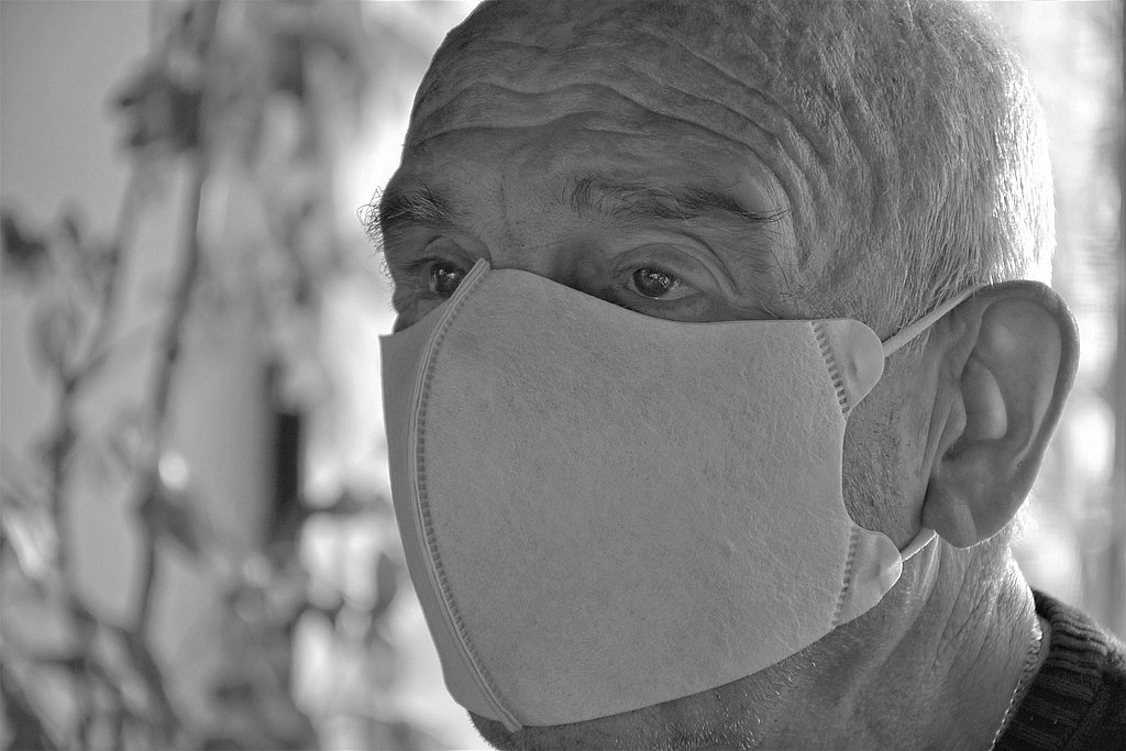Head of an old man wearing a mask.