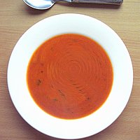 Ein Teller mit Suppe und einem Löffel