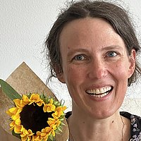 Portrait von Johanna Backes mit einer Sonnenblume