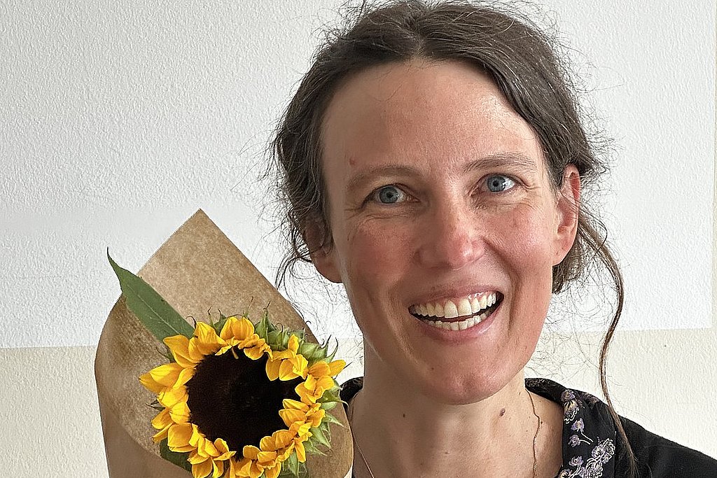 Portrait von Johanna Backes mit einer Sonnenblume
