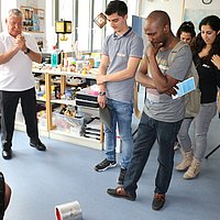 Interessierte des Pre-Study Programms stehen in der Lernwerkstatt der ASH Berlin im Rahmen einer Infoveranstaltung und schauen einem Experiment zu