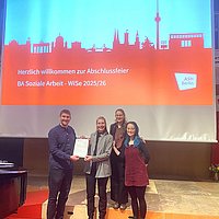 Das Foto zeigt Dr. Yannick Liedholz bei der Ehrung von drei Studierenden.