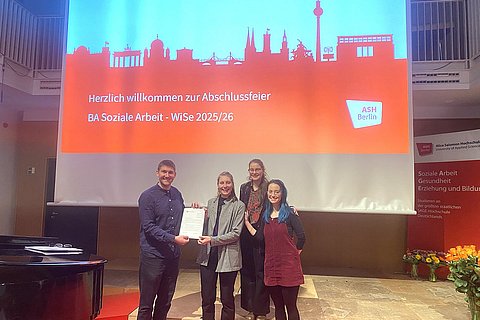 Das Foto zeigt Dr. Yannick Liedholz bei der Ehrung von drei Studierenden.