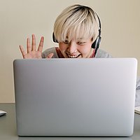 Vor einem Laptop schaut eine Person mit blonden Haaren in den Bildschirm