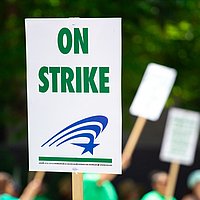 Ein Demonstrationsplakat mit der Aufrschrift: On strike!