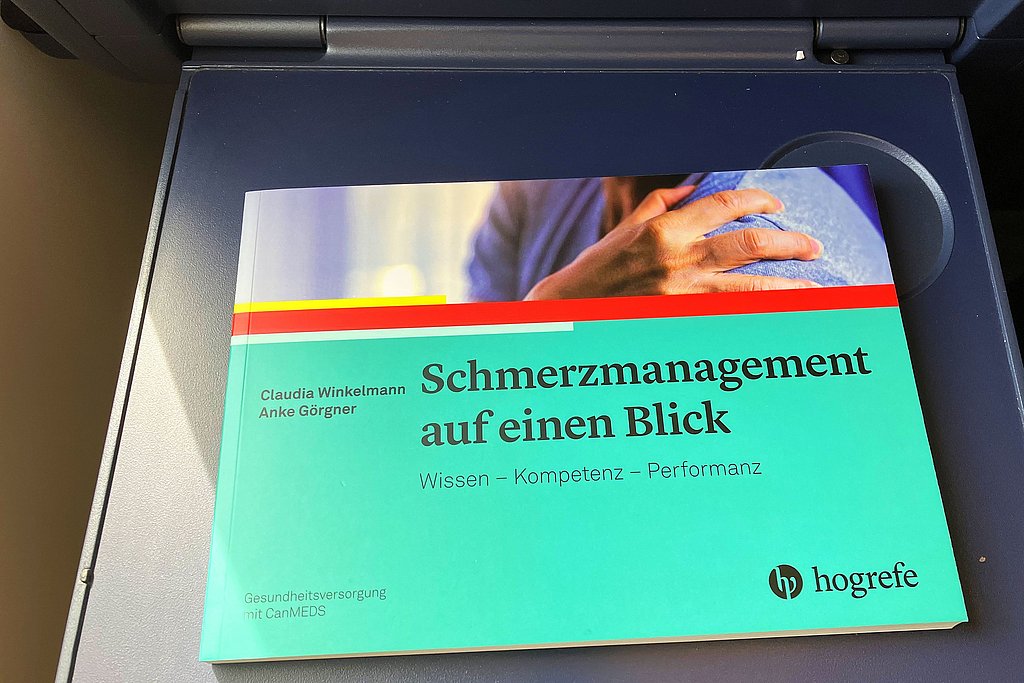 Das Buch „Schmerzmanagement auf einen Blick“ an Prof. Winkelmanns Lieblingsleseplatz: Im Zug