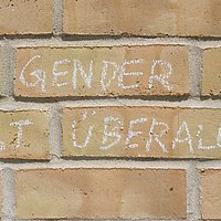 Mit Kreide ist der Spruch "Gender ist überall" an die Hauswand der ASH Berlin geschrieben