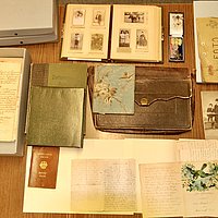 Old documents and photographs spread on a table