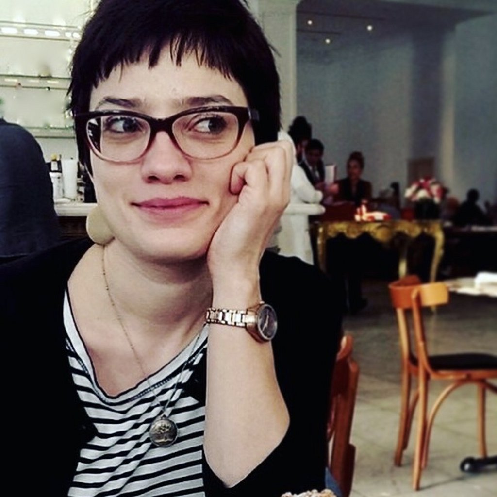 Porträt von Katja Schatte, die Hand auf das Kinn gestützt, mit Brille