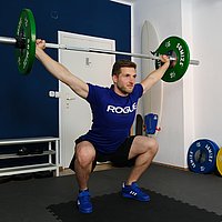 Ein Mann in Sportkleidung stemmt Gewichte