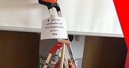 Eine Leiter im Audimax mit einem Schild mit der Aufschrift: Zentrum für individuelles und lebensbegelitendes Lernen - ZilLe 