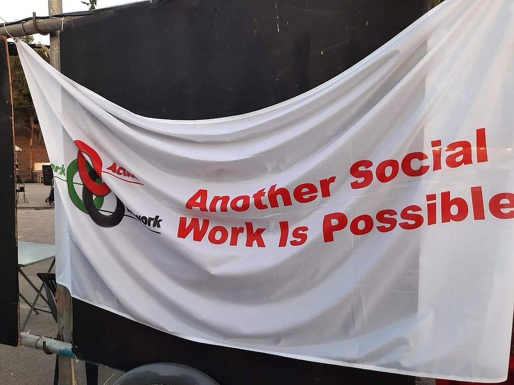 Eine weiß Fahne mit roter Aufschrift "another social work is possible"