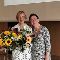 [Translate to Englisch:] Gudrun Piechotta-Henze mit Blumenstrauß und Bettina Völter