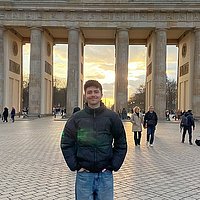 The photo shows the Spanish ERASMUS student Víctor del Amo Higueras in front of the Brandenburg Gate.