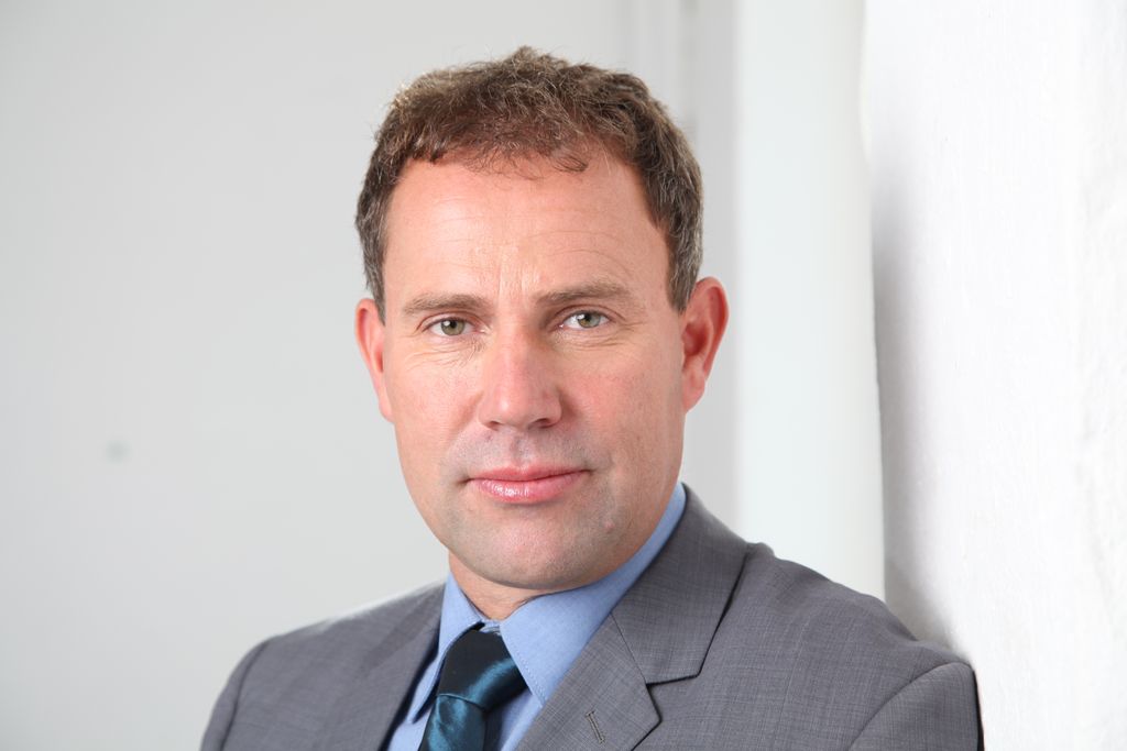 Vergrößern: Nils Lahmann trägt auf diesem Business Portrait Anzug und Krawatte. 