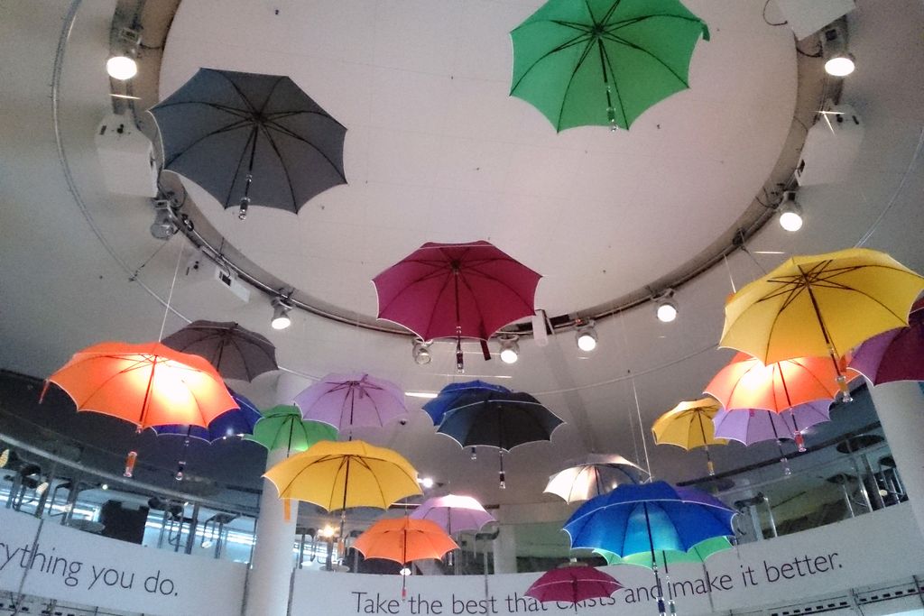 Vergrößern: Bunte Regenschirme hängen von einer Decke herunter