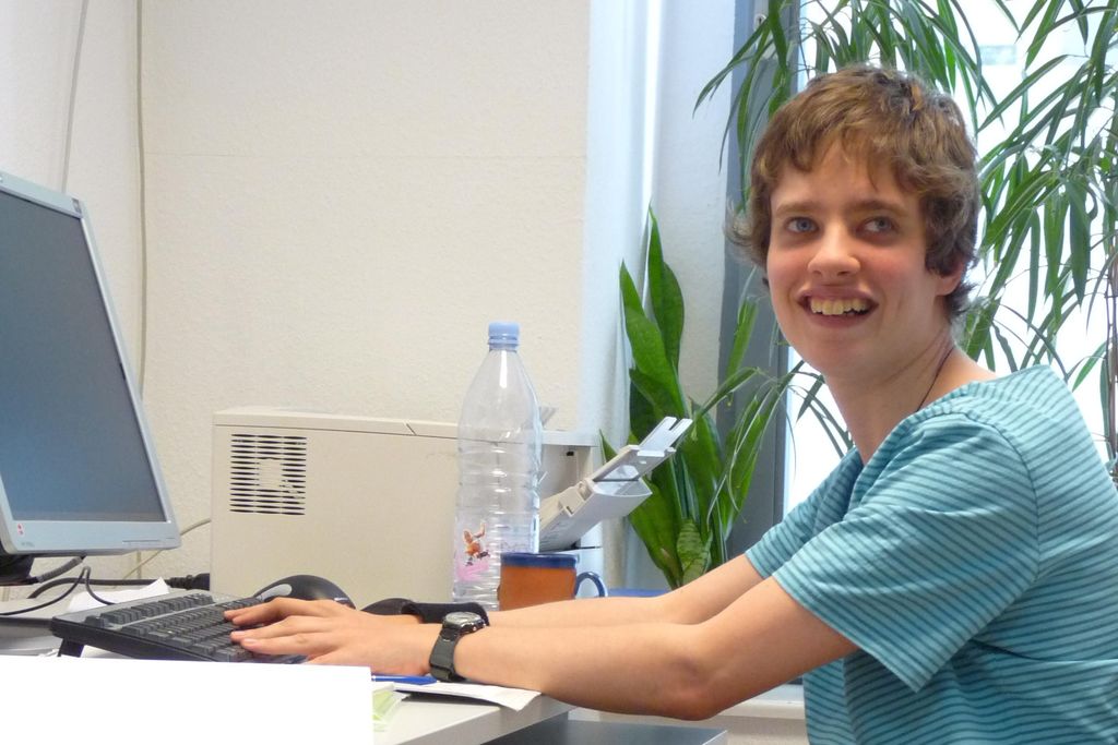 Vergrößern: Sarah Kokigei im Rollstuhl an ihrem Arbeitsplatz