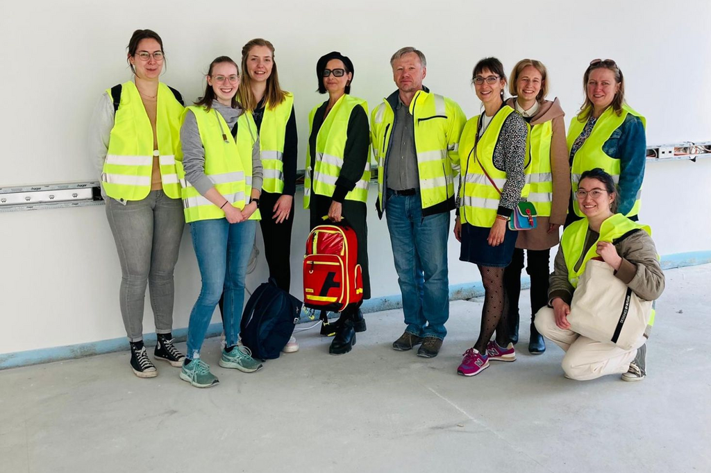 Gruppenfoto der Studierenden vor einer Betonwand im Neubau