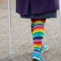 Buchcover mit Beinen von hinten mit bunten Socken und Krücken