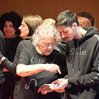 A group of older and younger people perform a play.