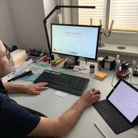 Uwe Bettig an seinem Schreibtisch vor dem Computer und mit Kopfhörern auf den Ohren