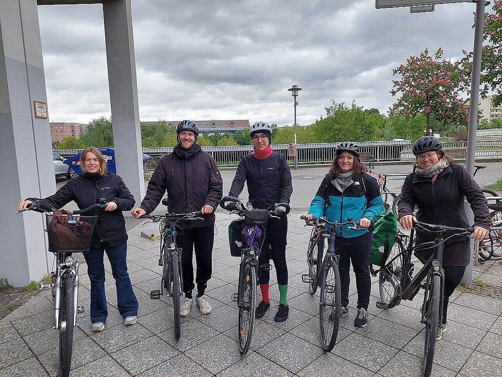 Foto von fünf Fahrradfahrenden vor dem Hauptgebäude der ASH Berlin