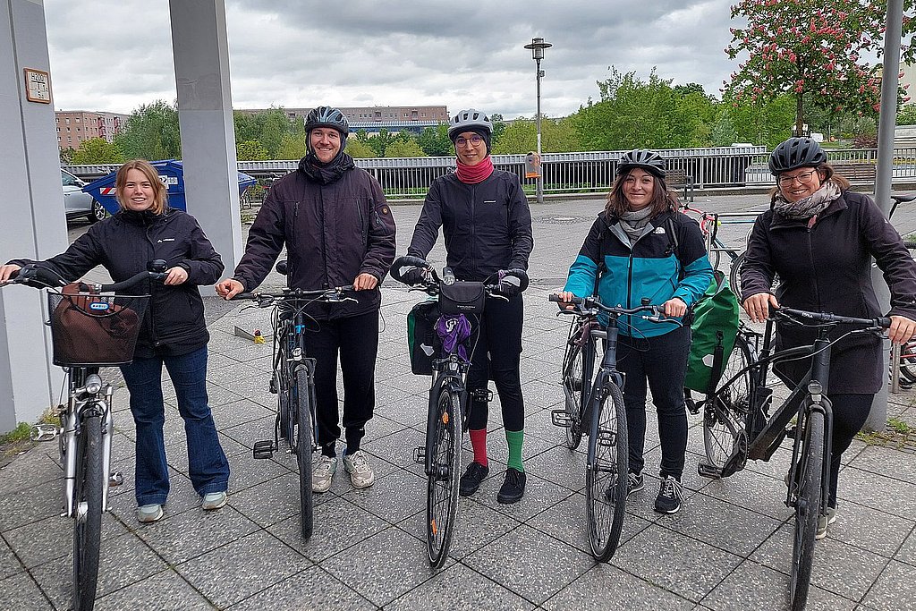 Foto von fünf Fahrradfahrenden vor dem Hauptgebäude der ASH Berlin